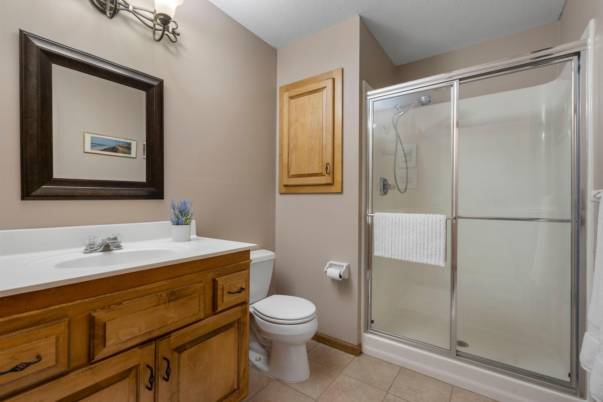 A nearby bathroom with a walk-in shower and medicine cabinet adds convenience.