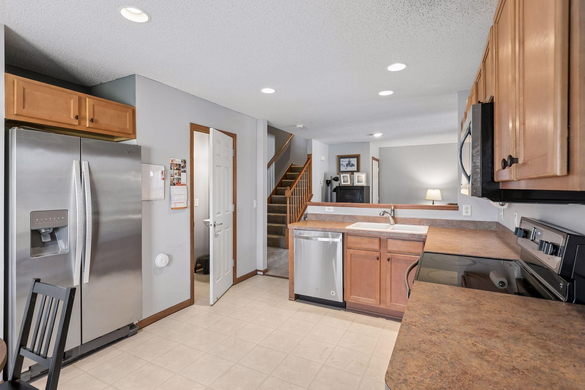 Kitchen features maple cabinets, stainless steel appliances and recessed lights.