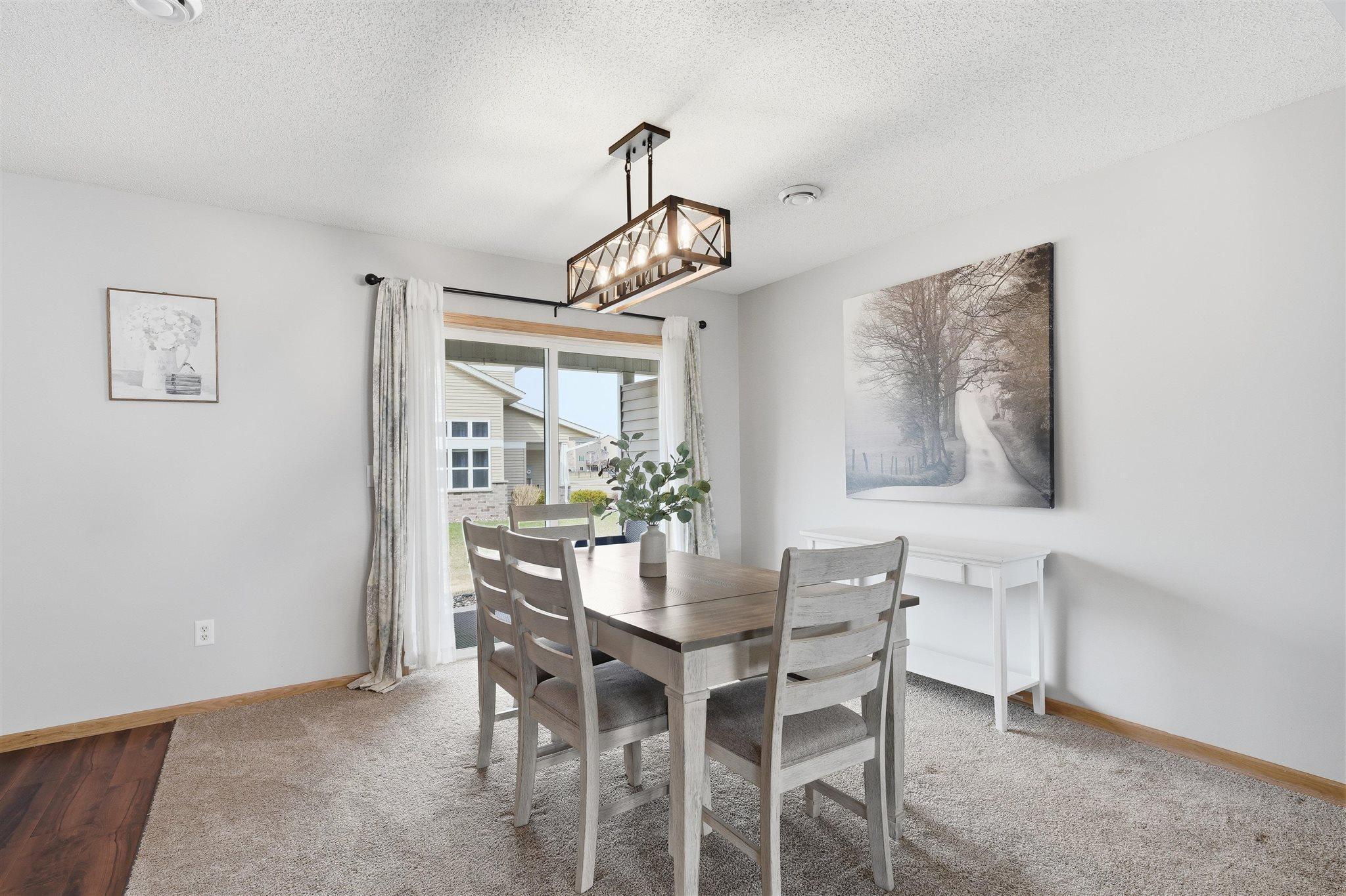Enjoy meals in this dining area with updated lighting and easy access to the patio