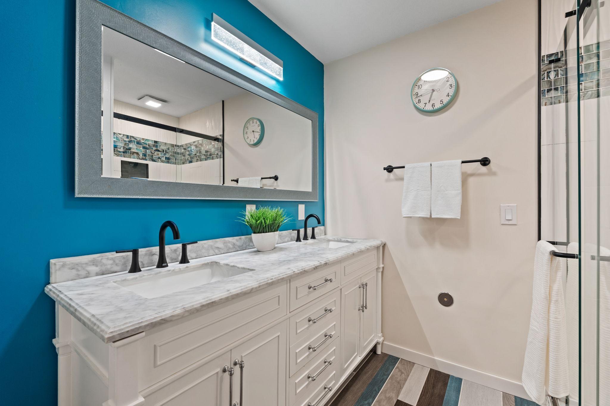 Lower level bathroom remodel in 2022 includes heater flooring, double vanity and custom tilework.