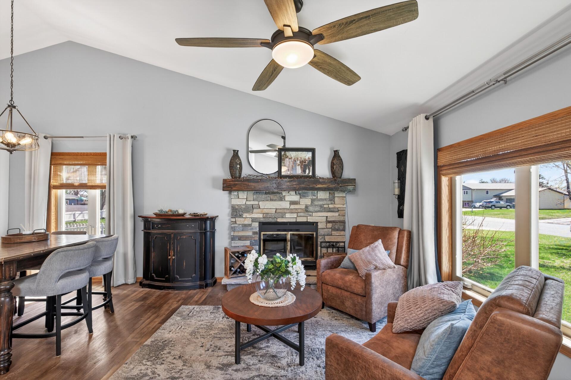Main floor living room with stone wood burning fireplace & wood mantle