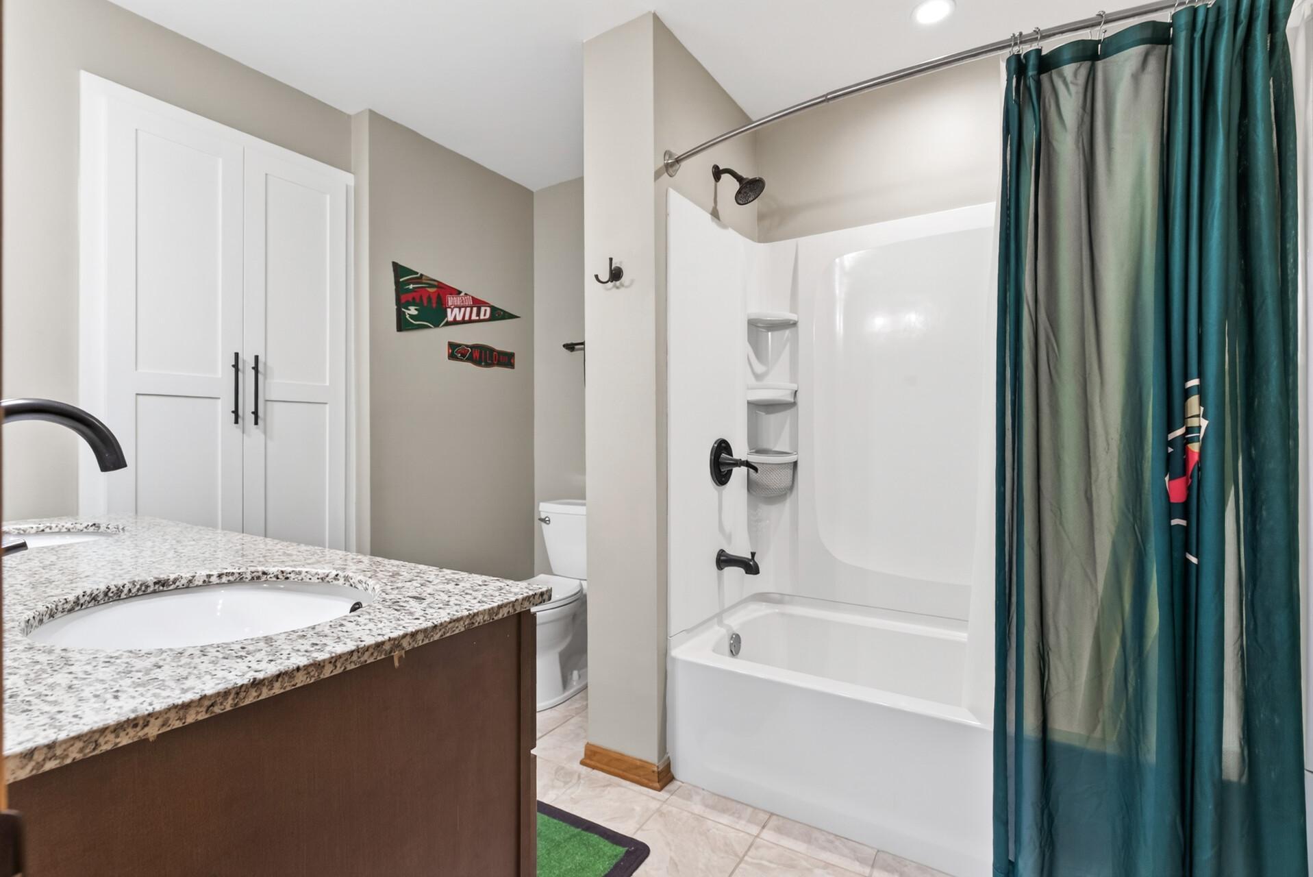 Upper level full hall tile bath with granite counter top on the dual sink vanity