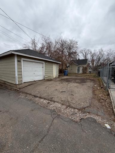 Spacious rear parking area with alley access leading to detached garage and additional off-street parking.