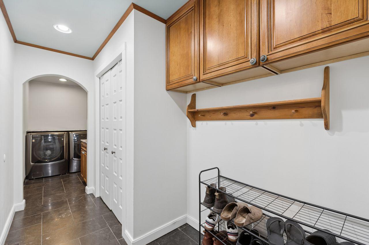 Rich cherry cabinetry paired with marble countertops adds both warmth and sophistication to the mud room.