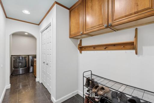Rich cherry cabinetry paired with marble countertops adds both warmth and sophistication to the mud room.