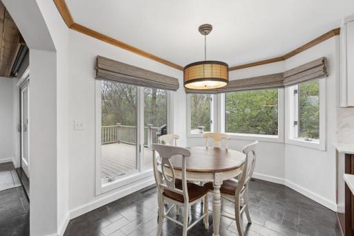 The informal dining area is ideally nestled between the kitchen and living room, where large windows invite an abundance of natural light