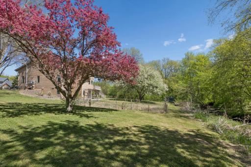Large fenced in garden area surrounded by mature trees