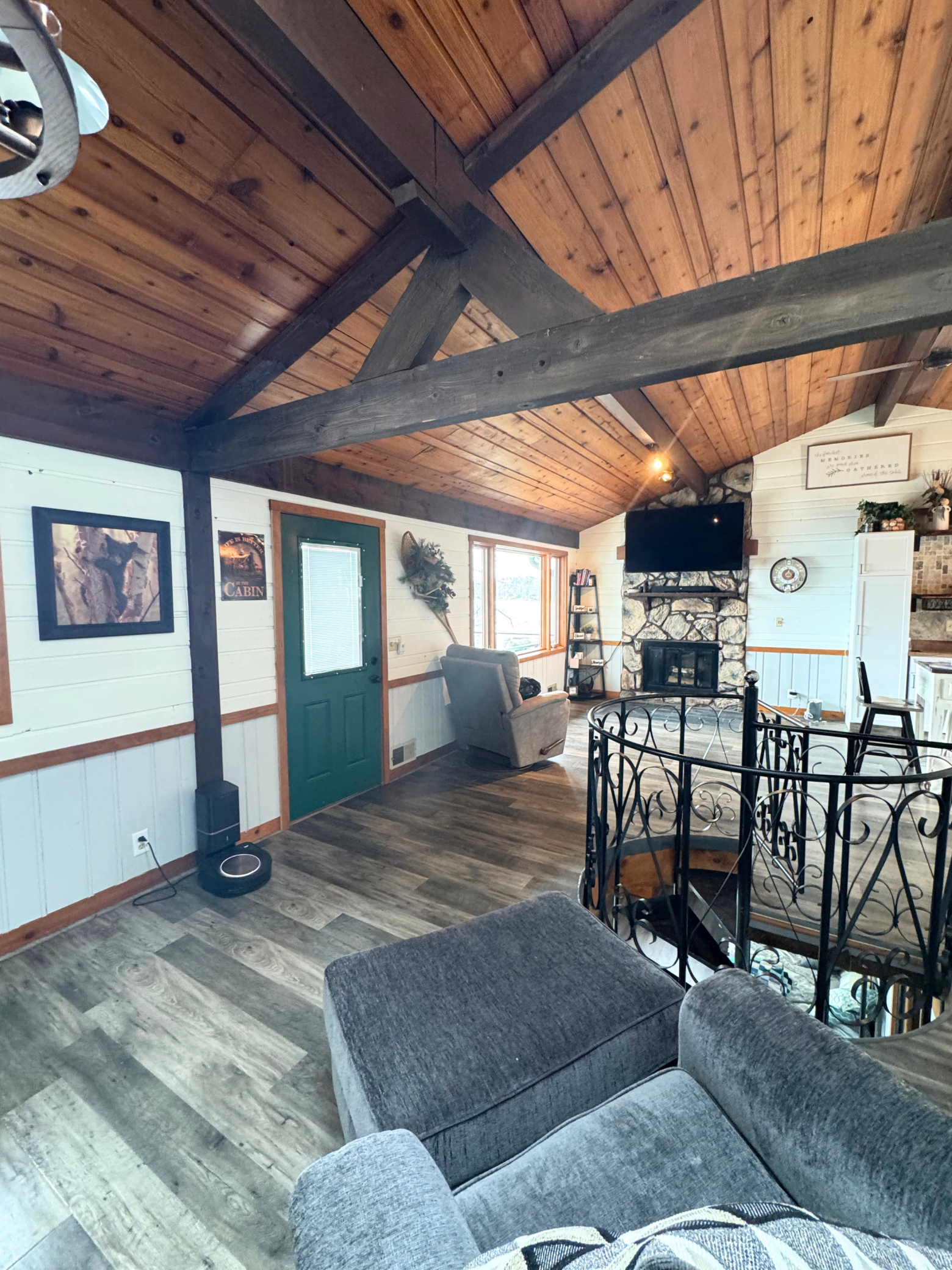 Photo from livingroom, vaulted ceiling with wood beams, fireplace, and access to the deck.