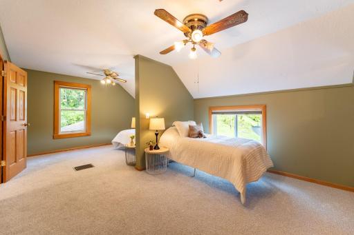 Bedroom 2 on the upper level. The unique partial wall creates two distinct sleeping areas, making this spacious bedroom an ideal setup for siblings or overnight guests.