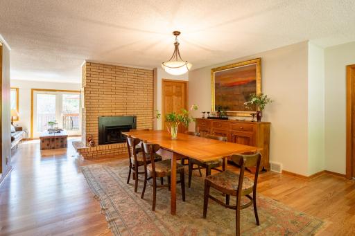 The dedicated dining room offers a timeless setting for entertaining, with the newer double-sided gas fireplace adding warmth and architectural character.