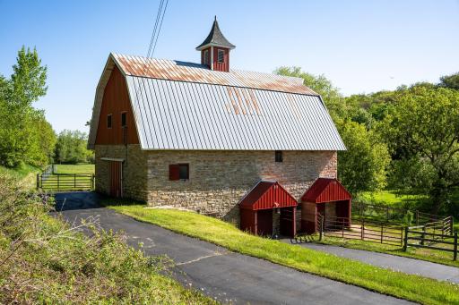 Multiple exterior barn doors on the east side leading into the fenced area and additional south-side access.