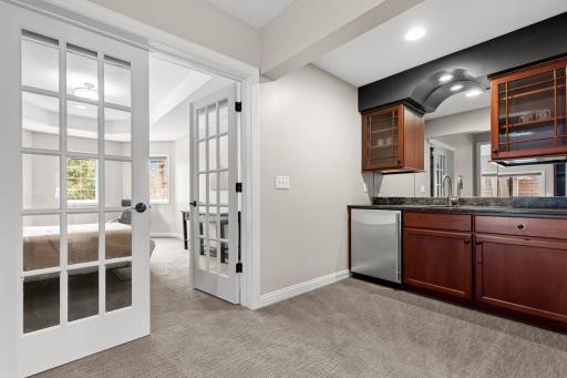 Wet Bar with Fridge and custom built-ins flows into bedroom 4 - Lower Level