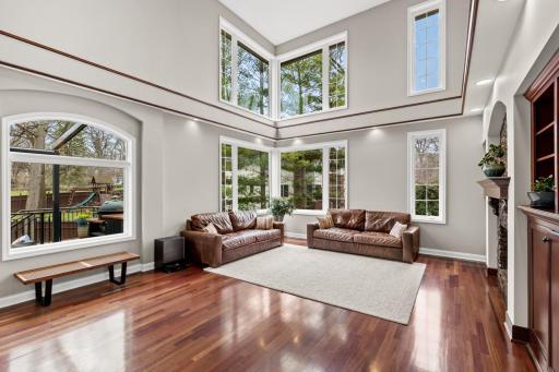 Soaring ceilings in the main floor living room allow for abundant light to stream in from the large windows.