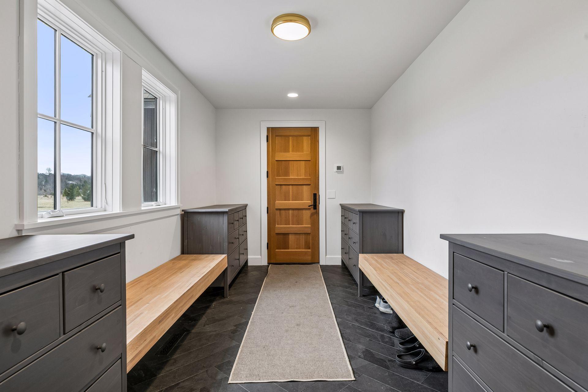 Impressively organized mudroom with heated slate flooring, recessed lighting, and loads of storage; designed for maximum functionality.