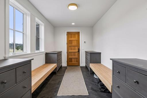 Impressively organized mudroom with heated slate flooring, recessed lighting, and loads of storage; designed for maximum functionality.
