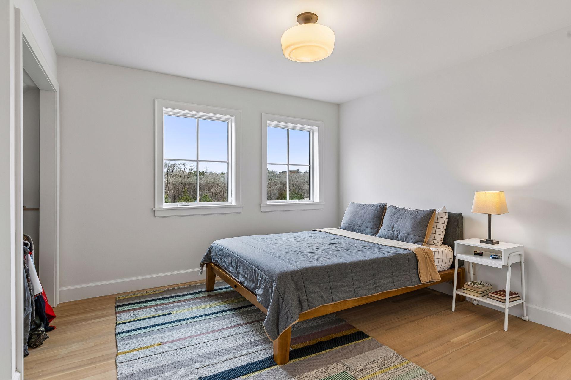 The third upper level bedroom offers hardwood floors, overhead lighting, three windows, and a practical closet.