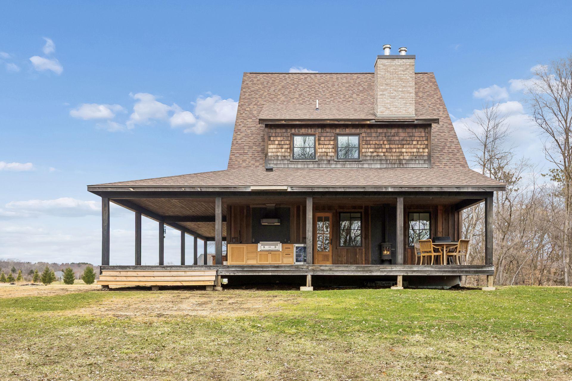Stunning covered wrap around porch, offering expansive outdoor living space and seamless connection to the surrounding landscape.