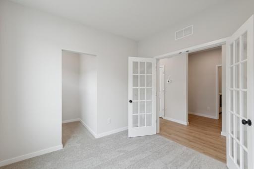 Versatile flex room with French doors and a convenient storage niche, offering additional space for shelving, organization, or custom built-insâperfect for a home office, study, or hobby room.