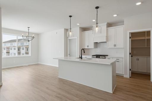 Another view of the kitchen. Notice the sneak peak of the walk-in morning pantry. This pantry features bottom cabinets and upper open shelving to keep you organized.