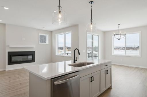 Functional center island with quartz countertops provides extra workspace and gathering space.