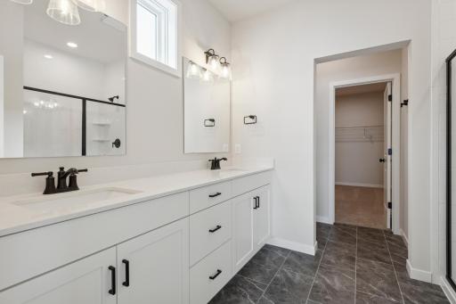 Primary bath showcases a dual-sink vanity complemented by modern black hardware.