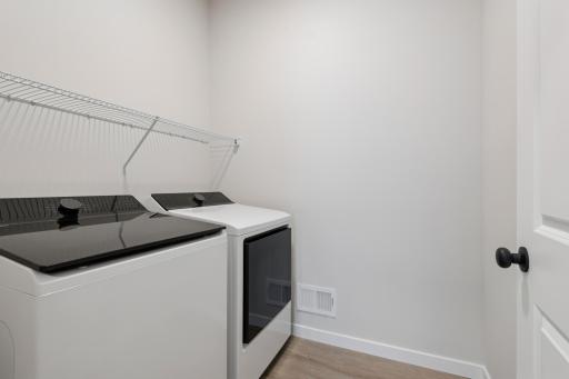 Convenient main level laundry room with side-by-side washer and dryer, designed for easy access and everyday efficiency.