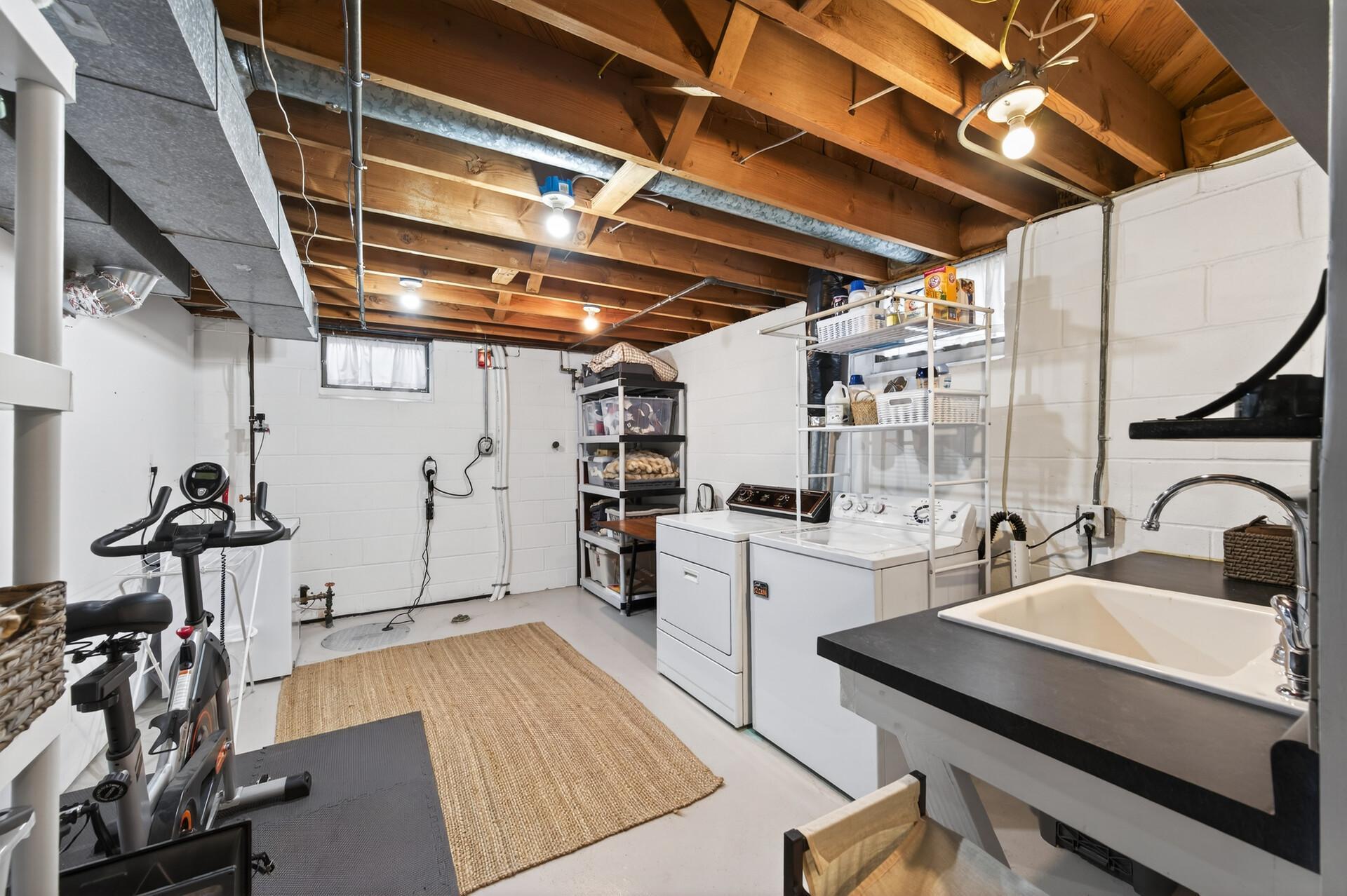 Large, bright laundry room with a laundry tub/sink.