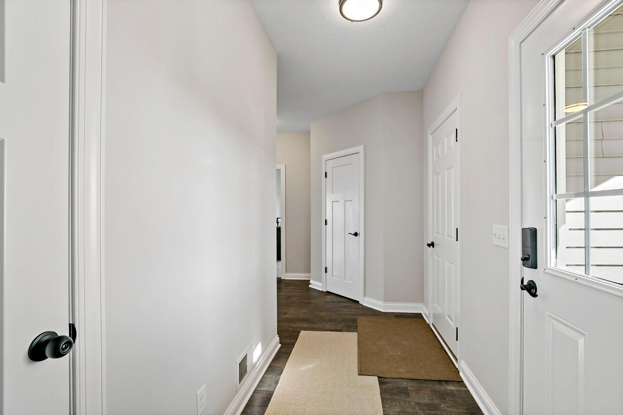 Bright entry hallway with modern finishes and dark wood flooring.