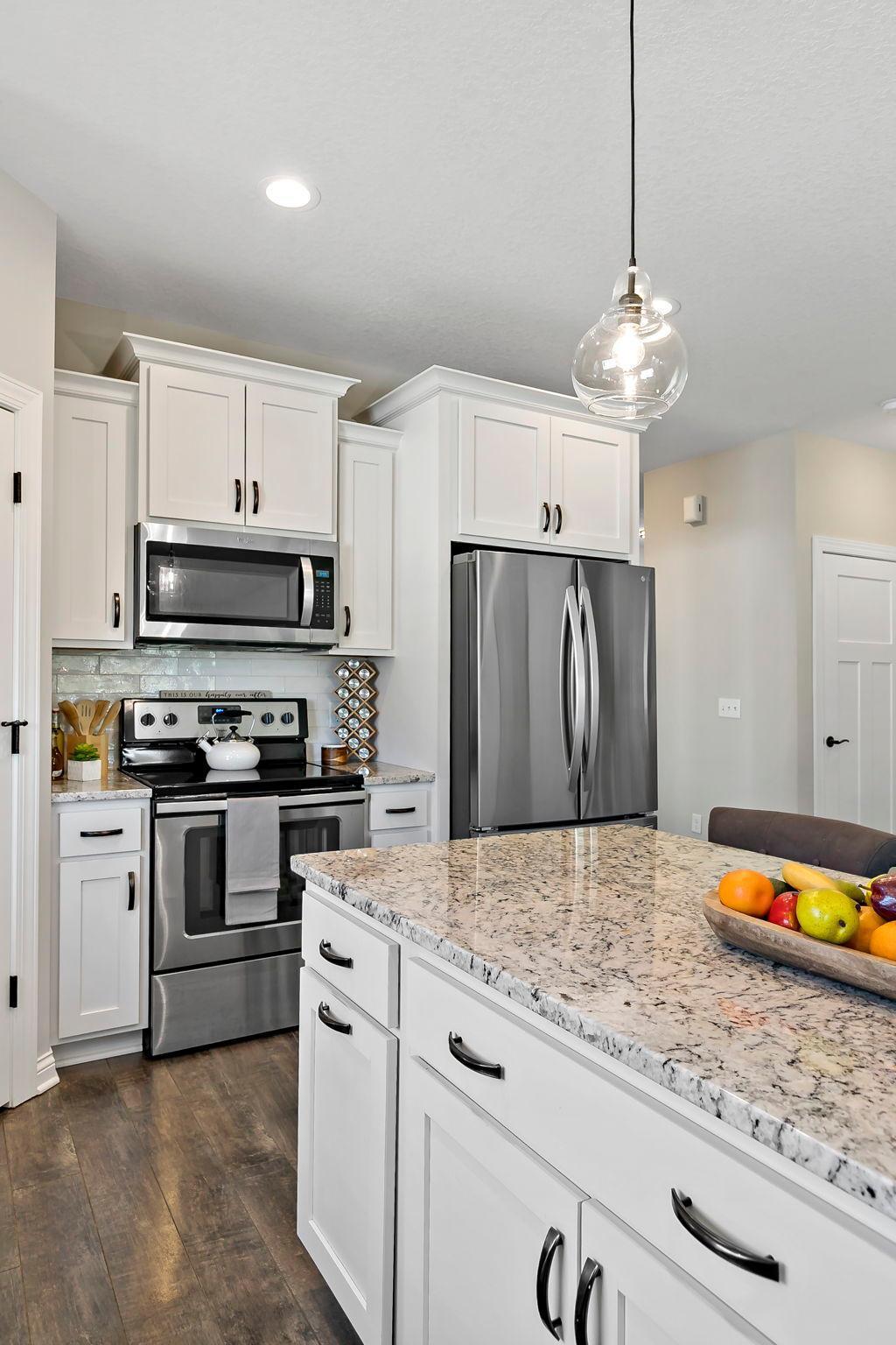 Stylish kitchen with granite island, stainless steel appliances, and upgraded cabinets.