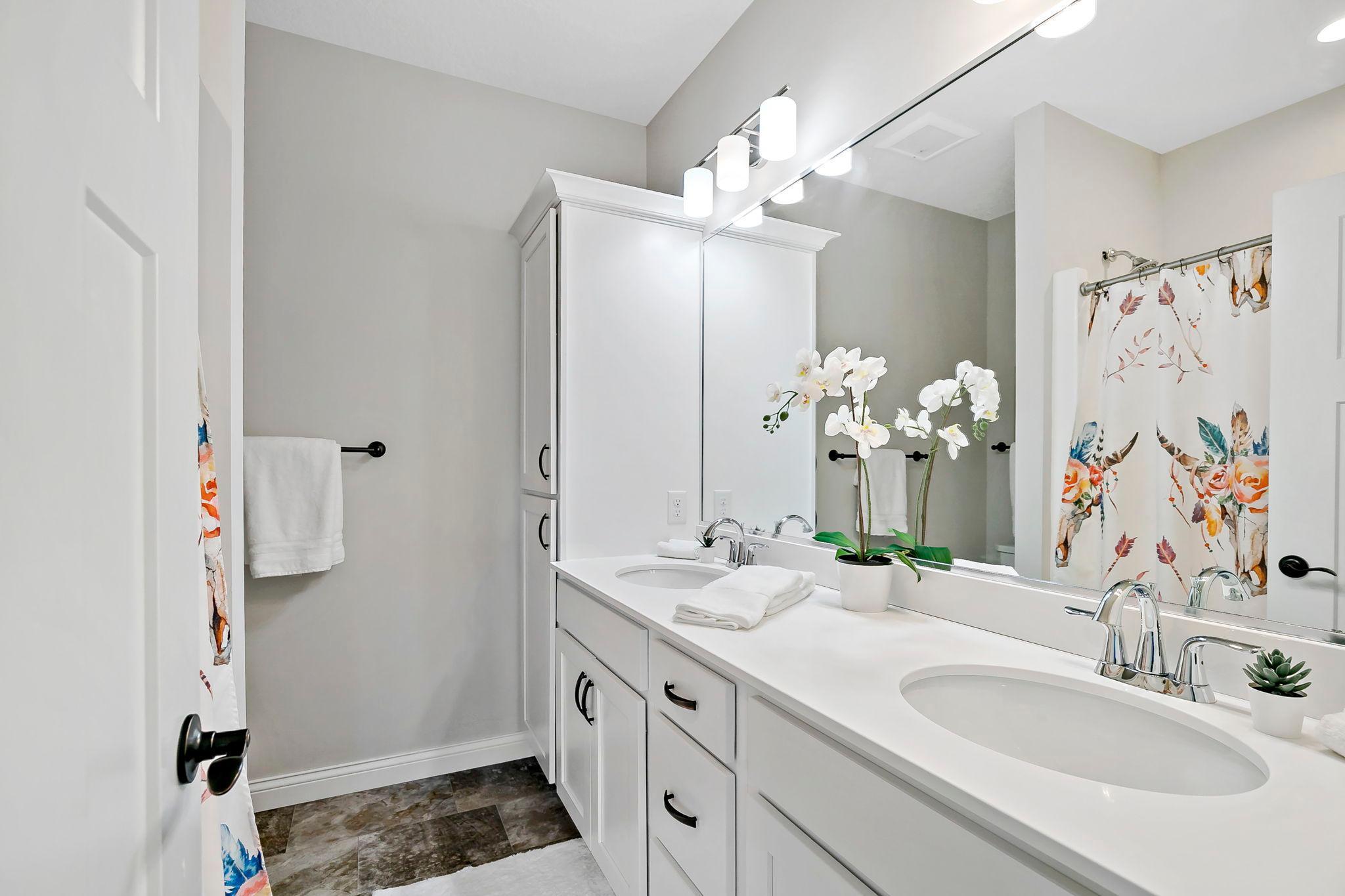 Bright bathroom with double vanity, modern fixtures, and ample counter space.