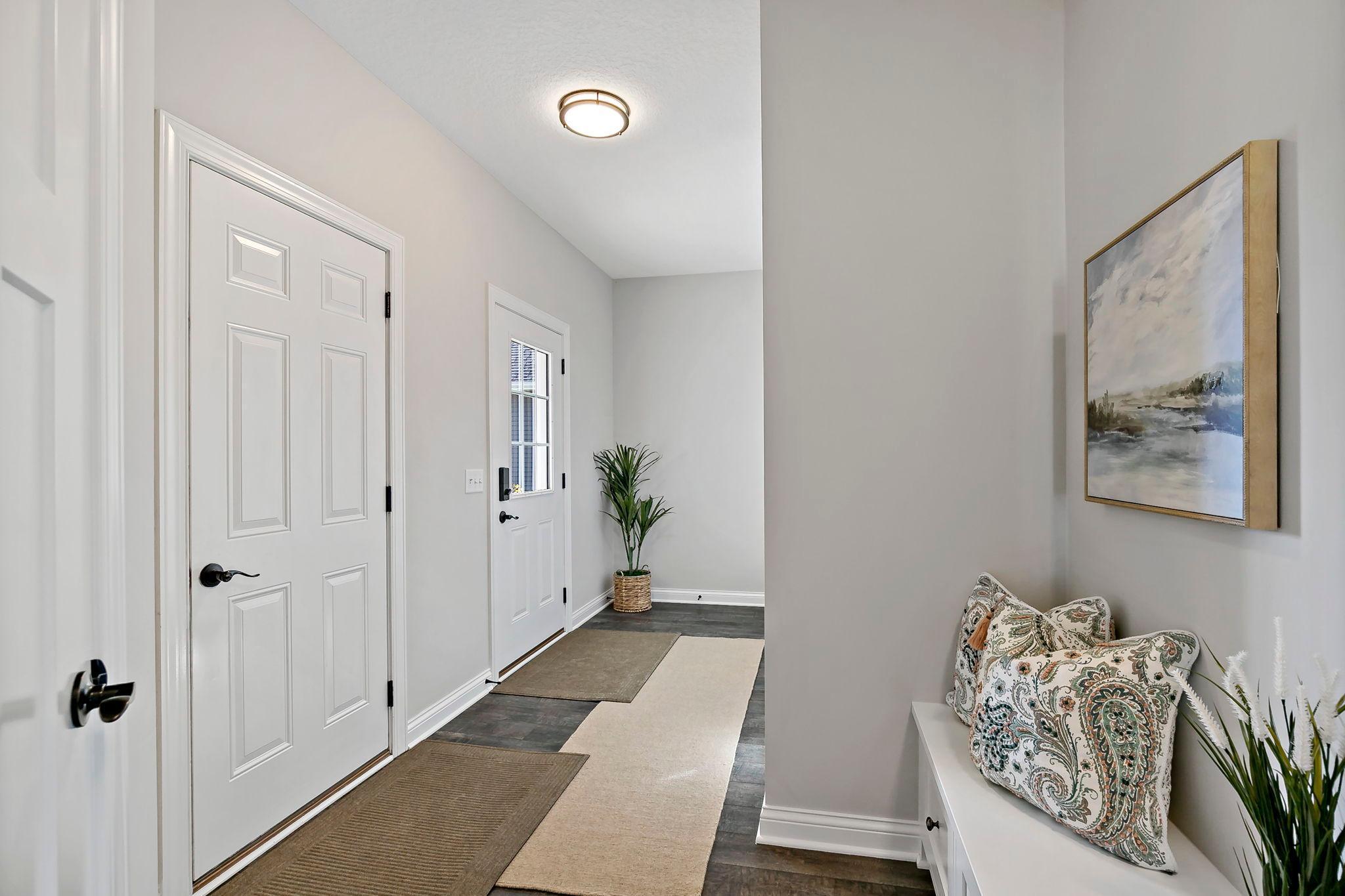 Bright and welcoming entryway with neutral tones and stylish accents.