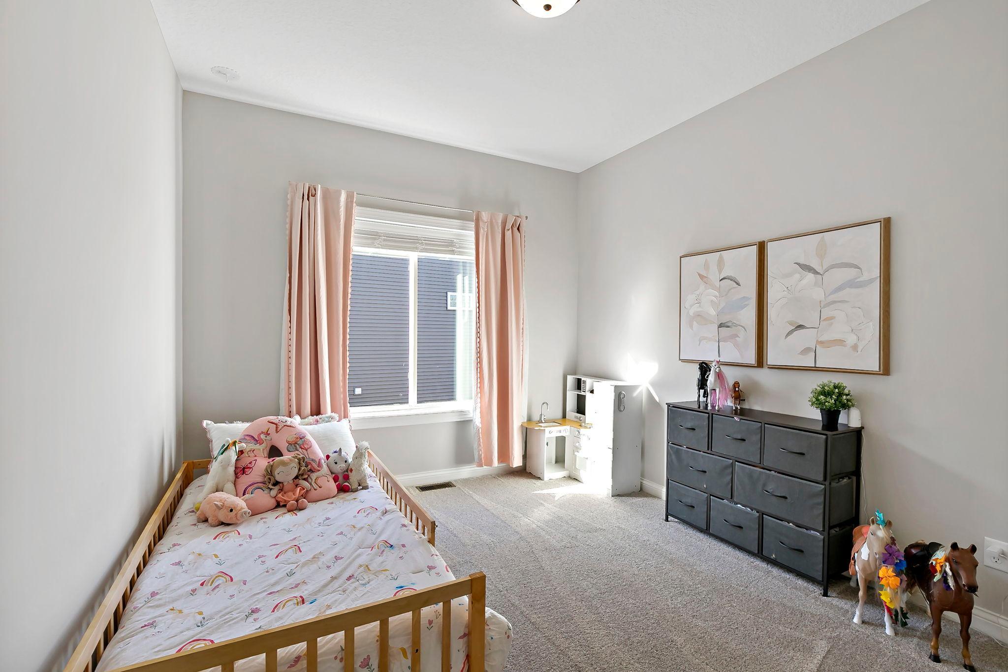 Cheerful and airy bedroom with soft pink accents and plenty of natural light.
