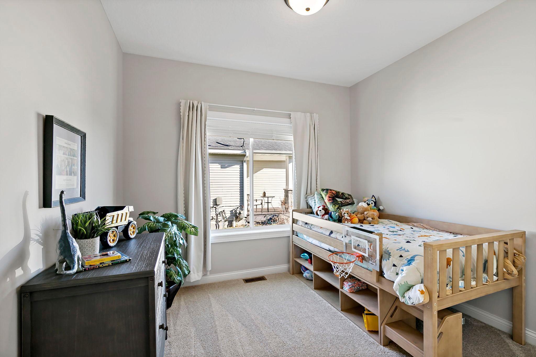 Bright and cozy children’s bedroom with playful decor and a window view.