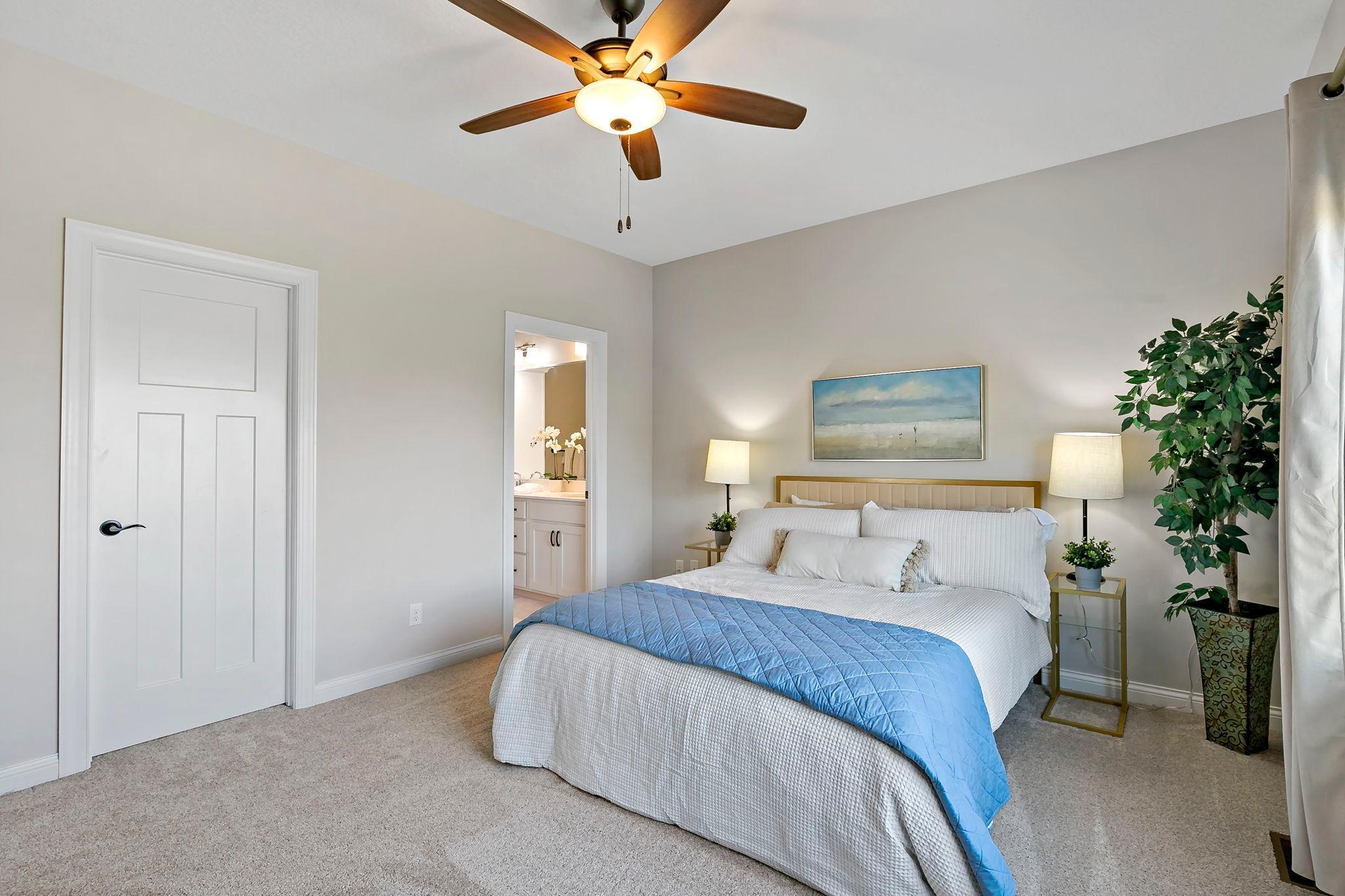 Serene primary bedroom featuring soft neutral tones and a private ensuite bath.