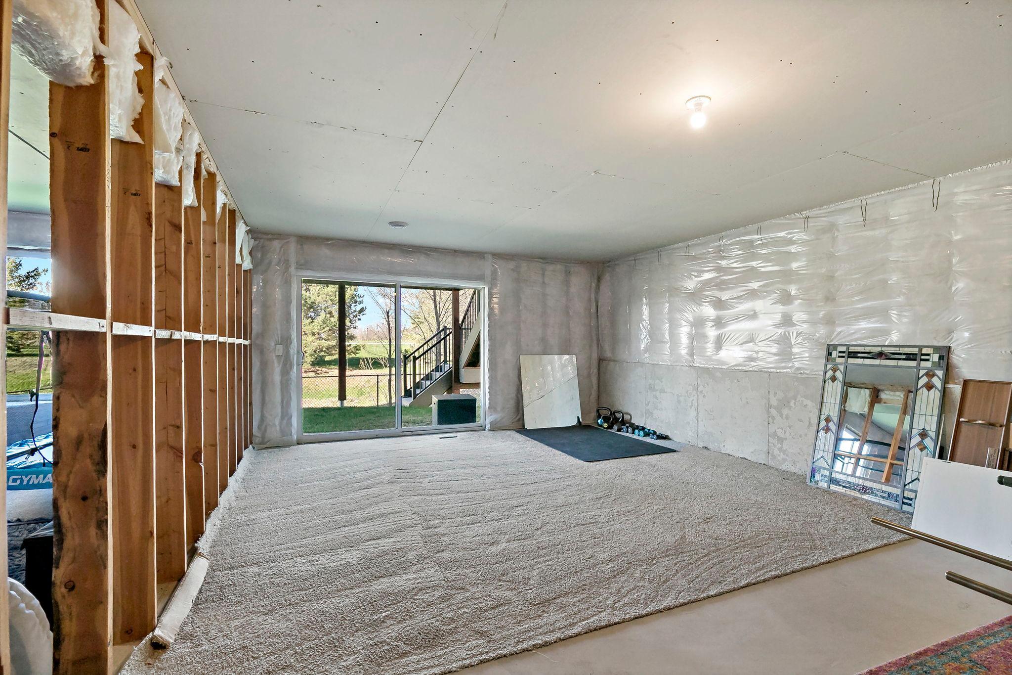 Walk-out basement space with framed walls and sliding glass door to the backyard, ready for your finishing touches.