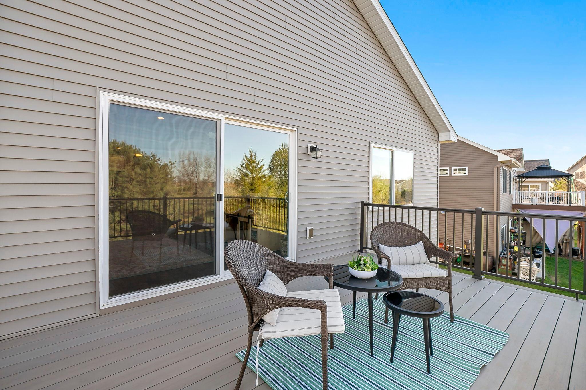 Inviting upper-level deck with comfortable seating and sliding glass door access.