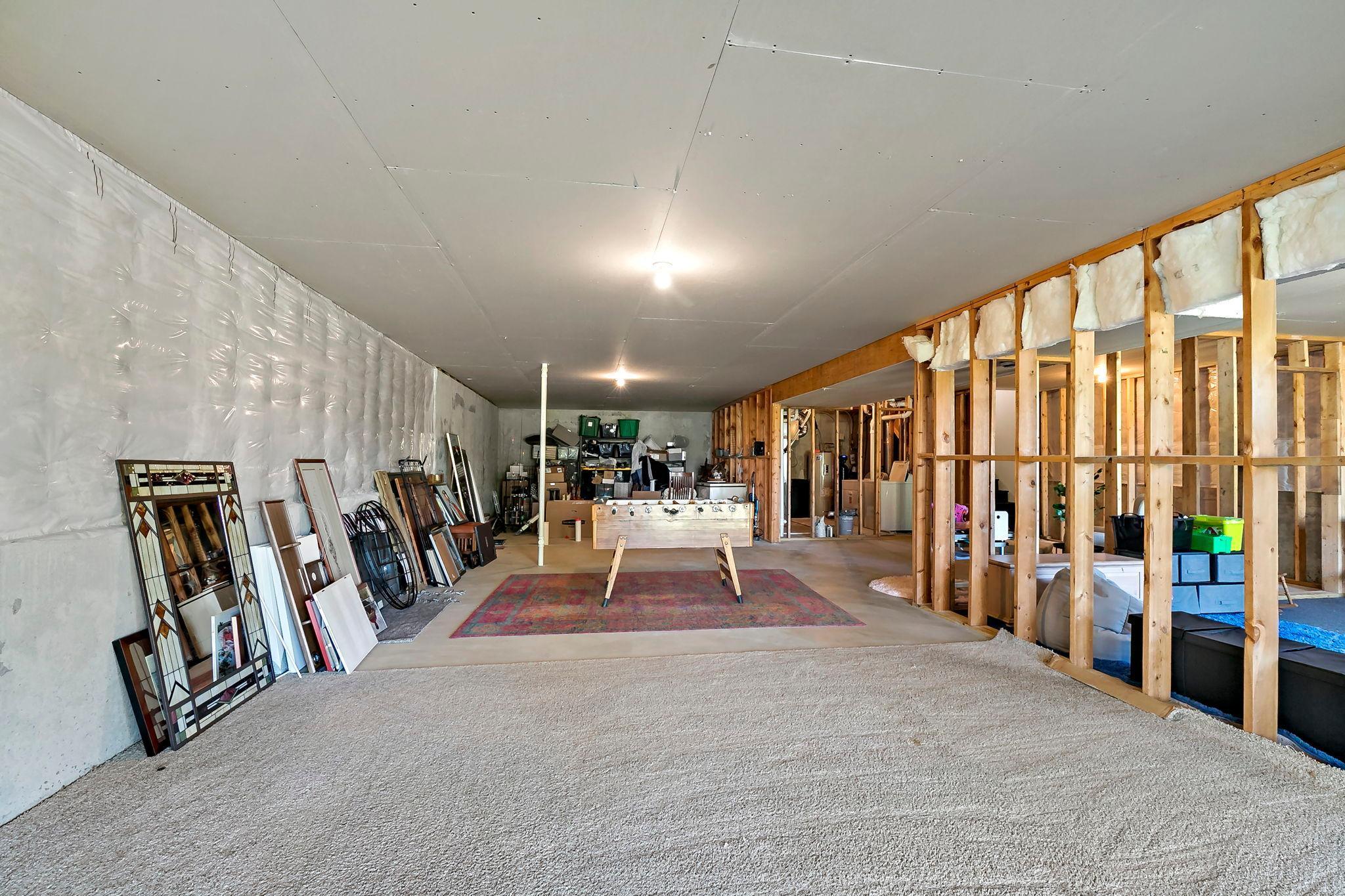 Expansive unfinished basement with framed walls, offering abundant space for storage, recreation, and future customization.