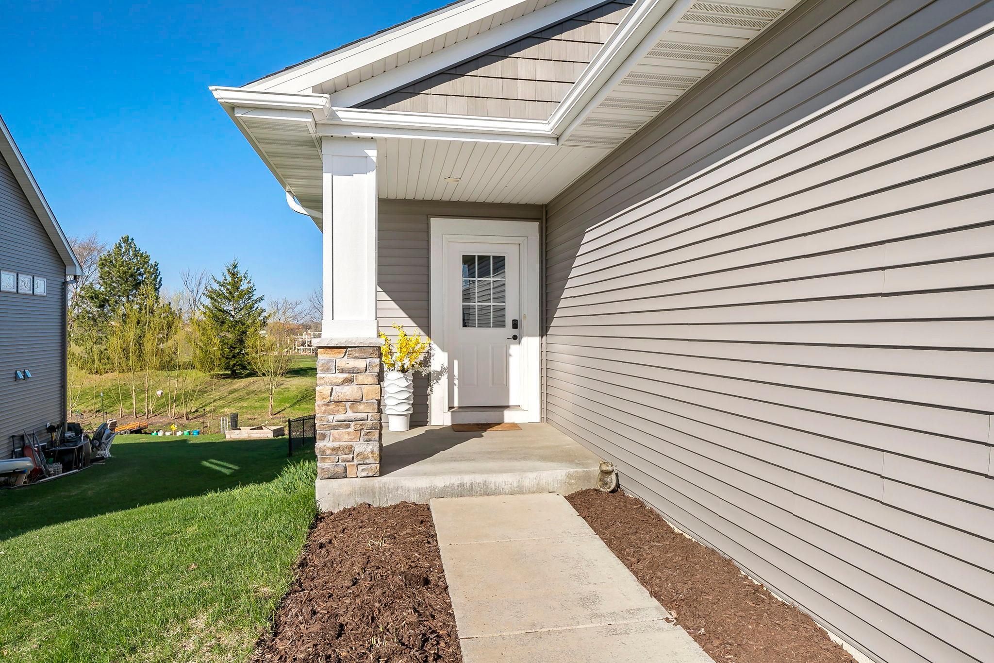 Charming covered entry with stone-accent column and private side yard access.