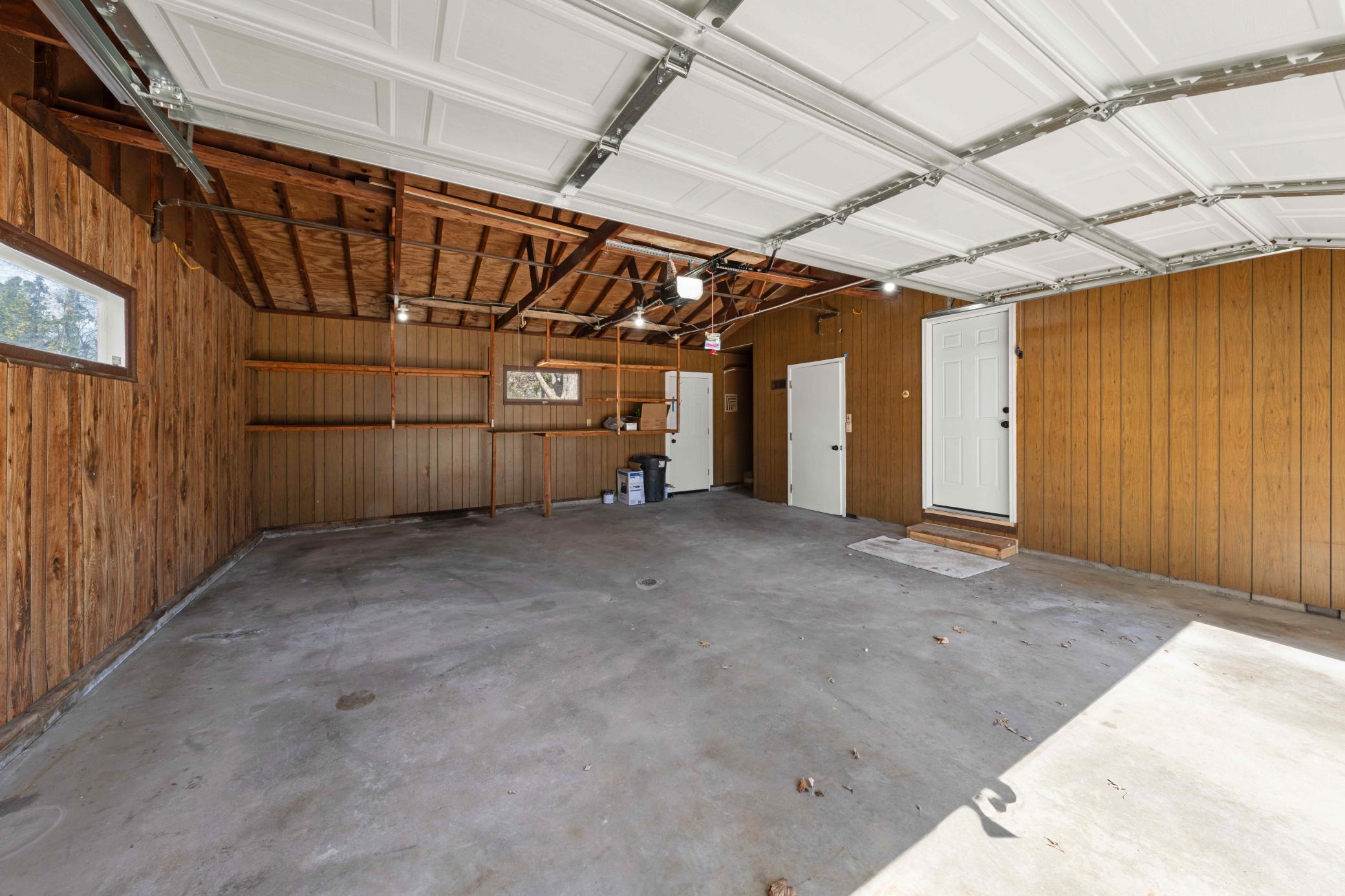 Extra deep 2 car attached garage with extra storage room and access door to backyard