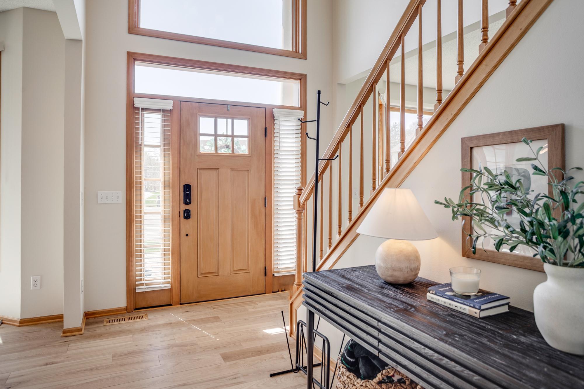 A dramatic two-story foyer creates an inviting first impression, seamlessly opening to both the formal dining room and living room, while flooding the space in natural light. Fresh paint throughout the main and upper level!