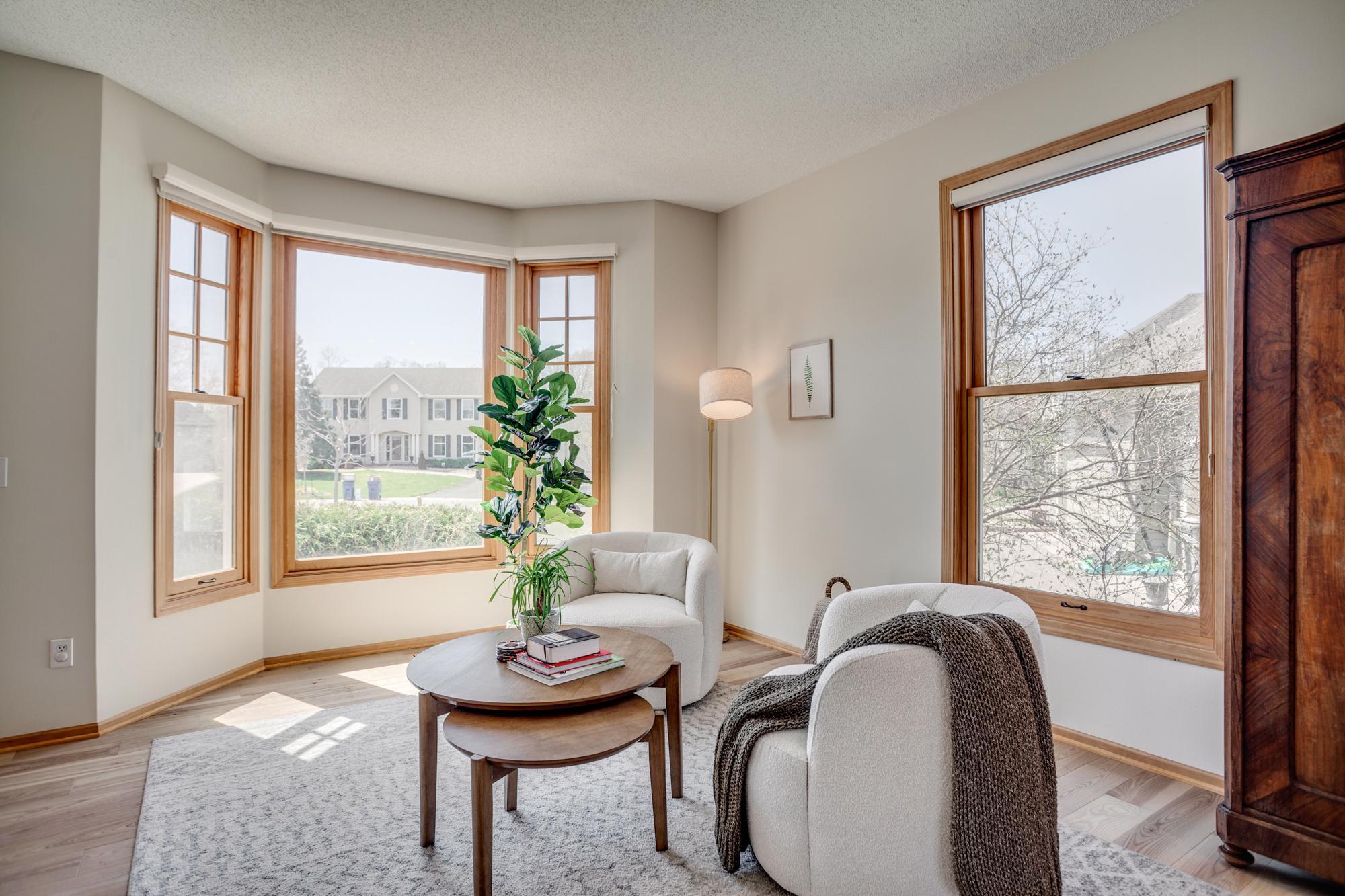 The living room is bathed in natural light and features glass French doors which open to the family room, creating a flexible layout that allows for both open flow and defined spaces when desired.