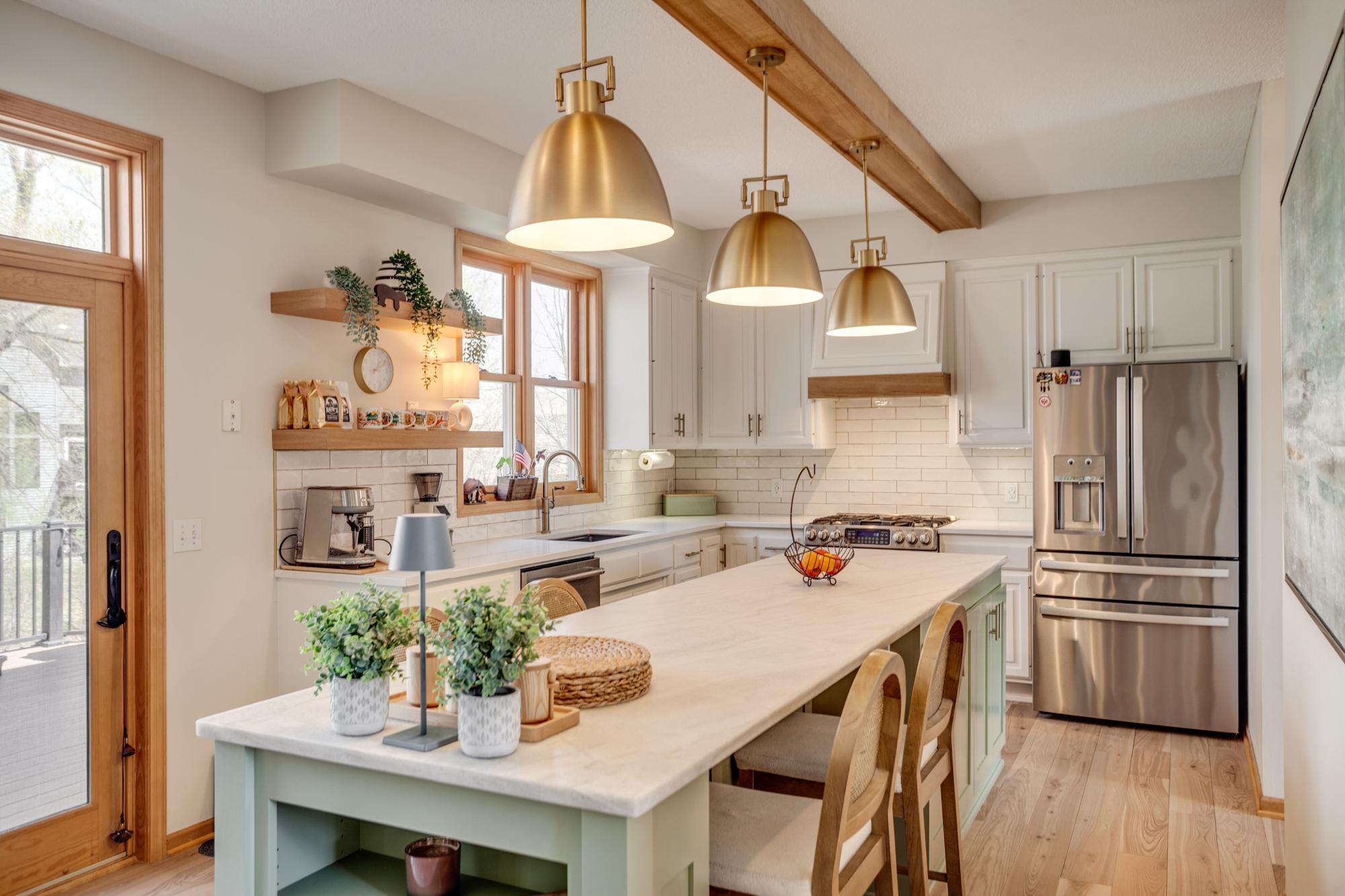 Absolutely stunning, the redesign included updated enameled cabinetry, floating shelves, quartz countertops, subway tile backsplash, new lighting, and stainless-steel appliances.