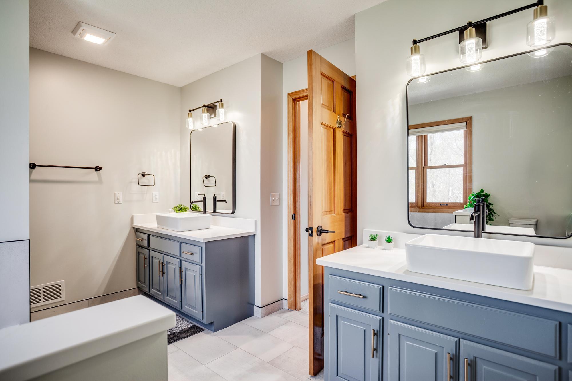 Updated bath with new countertops, vessel sinks, and fixtures enhancing the dual vanities!
