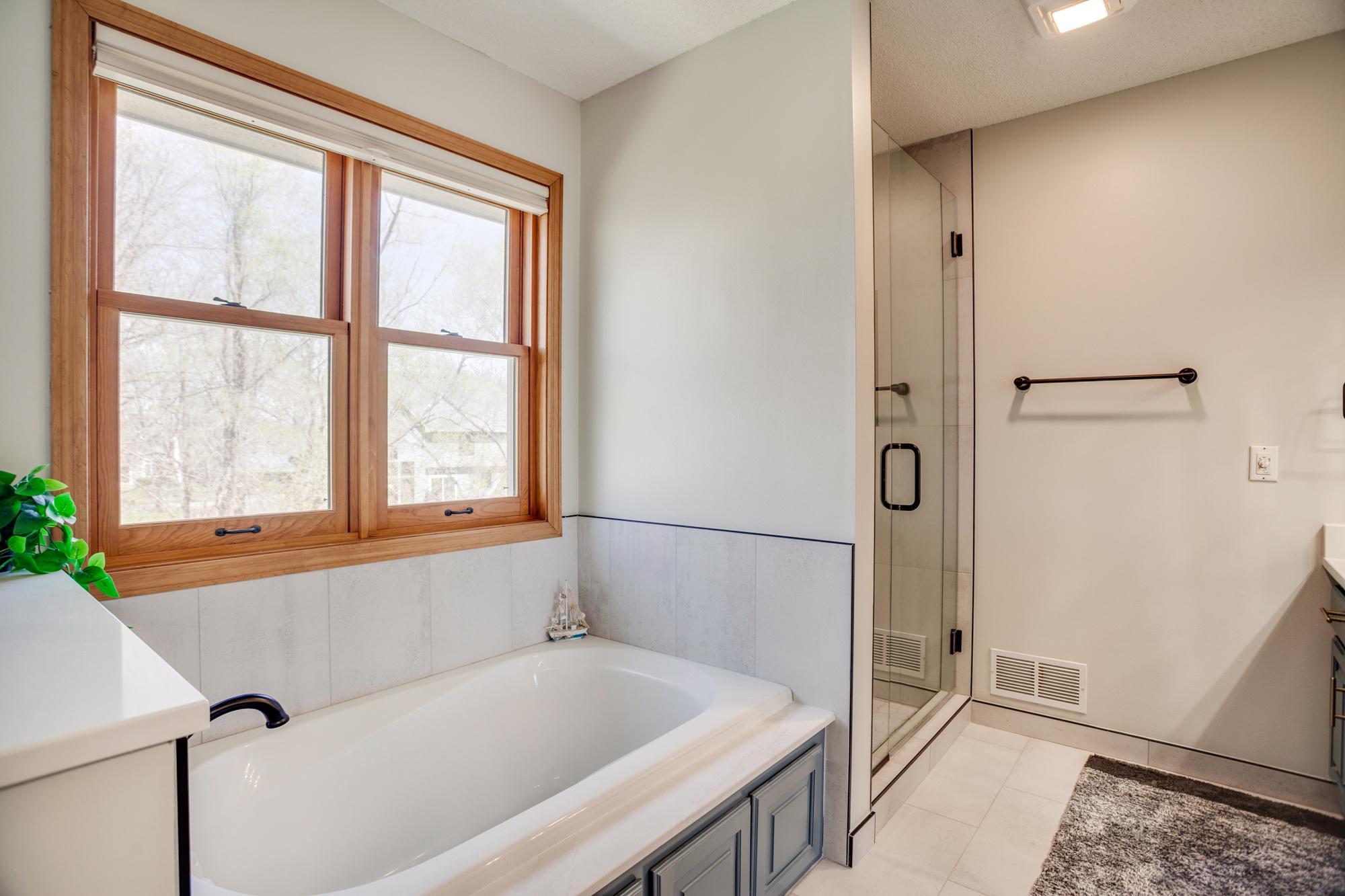 Primary bath also includes a relaxing soaking tub, and walk-in shower with glass door and new, custom tile surround.