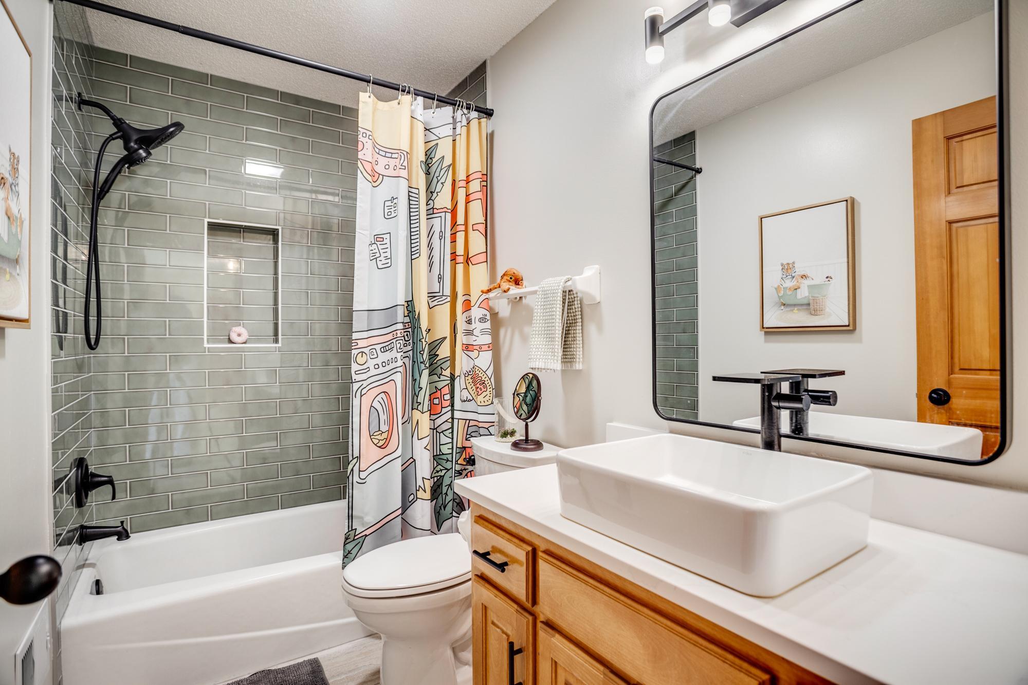 The additional bedrooms in the upper level are served by the full bathroom in the hallway, also nicely updated with a new vessel sink, countertop and fixtures + fantastic subway tile bath surround.