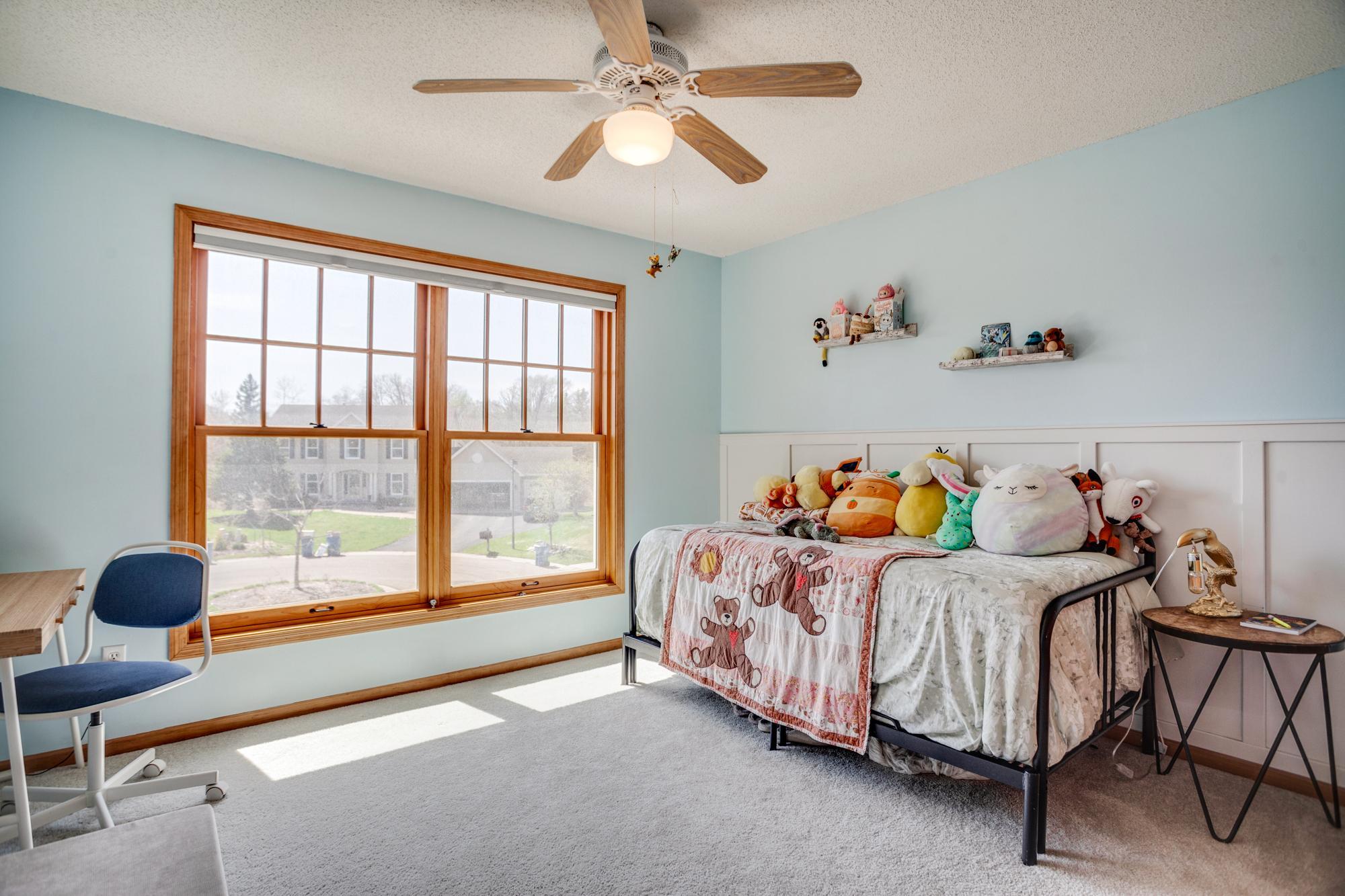 Another bedroom with oversized windows and charming wainscoting accents.