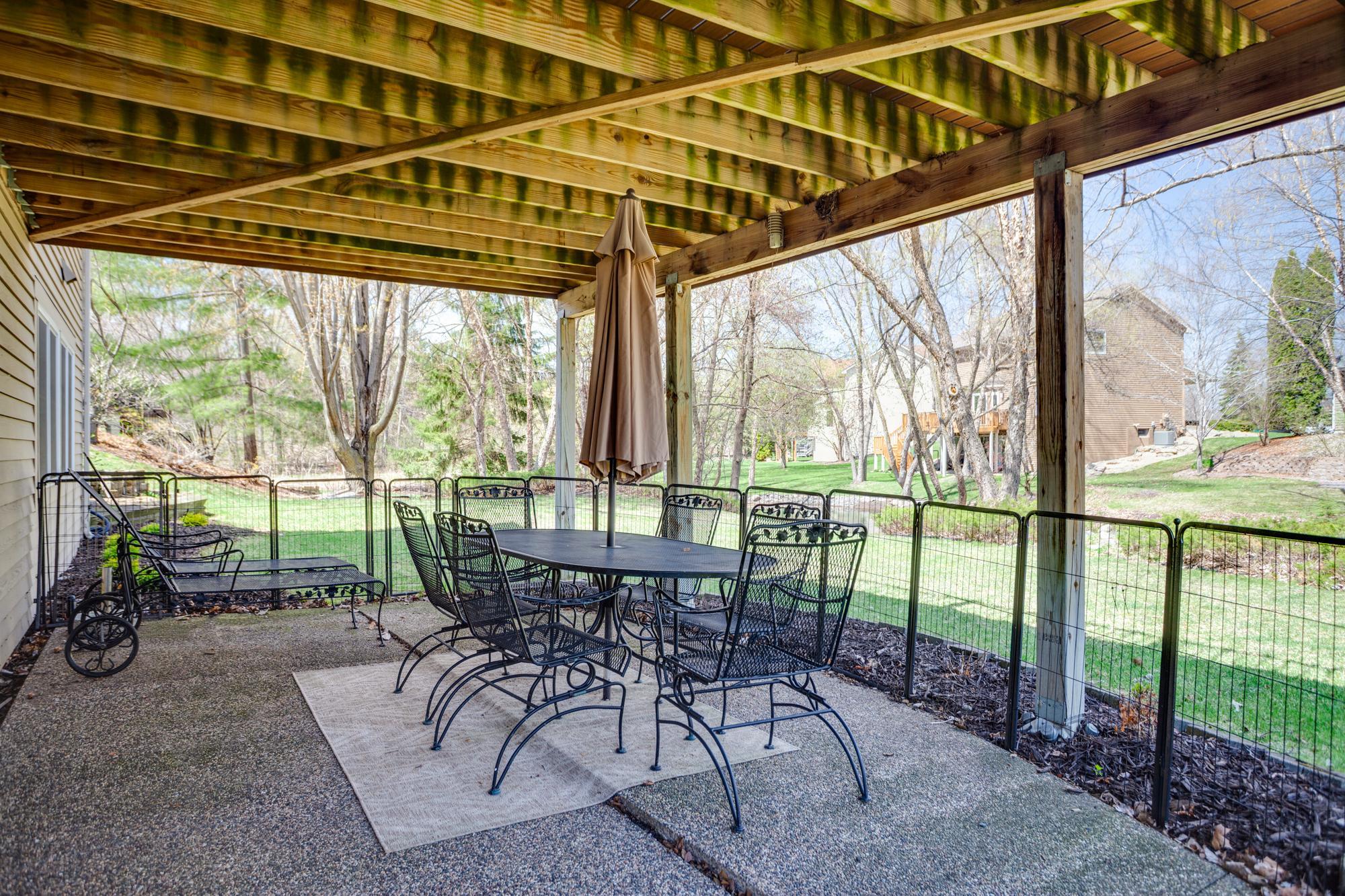 Large backyard patio area steps directly out to the open green space and pond.