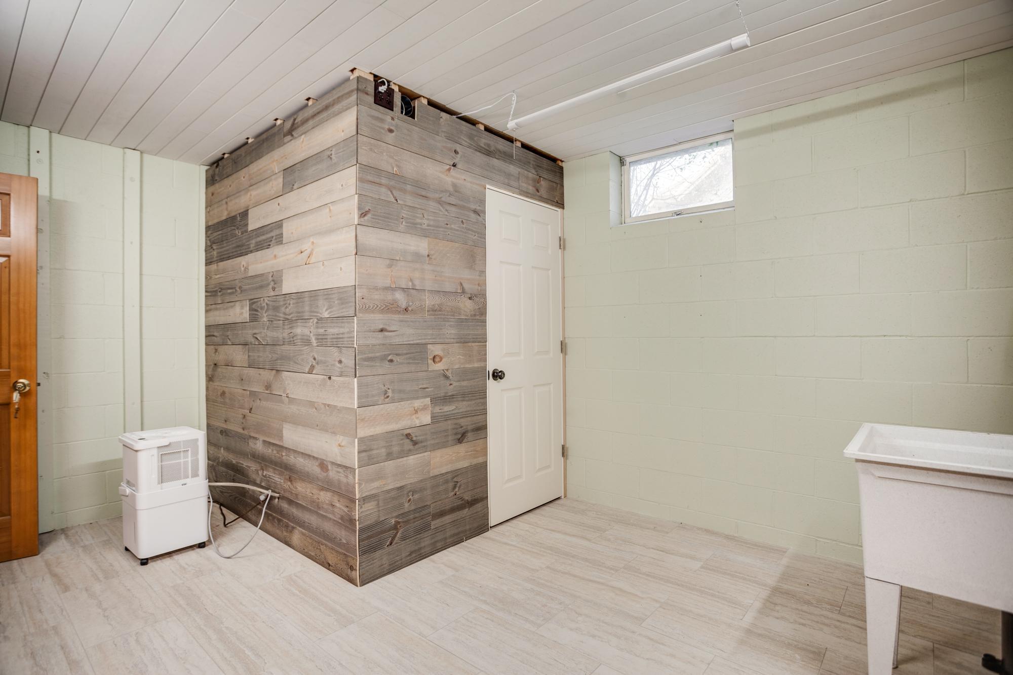 Large storage room in the lower level with new tile flooring, closet, sump pump w/battery backup, shiplap ceiling, and a handy utility sink. The built-in closet which could be utilized as a future sauna.
