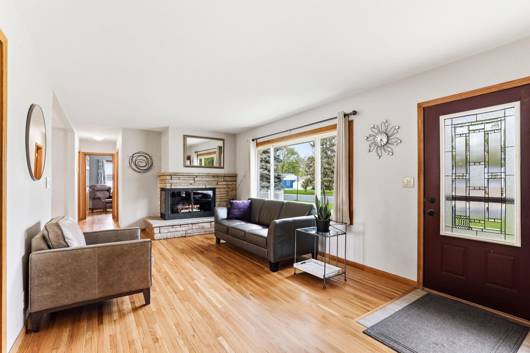 Spacious living room anchored by a charming fireplace creating a welcoming atmosphere. The hearth adds character and warmth,