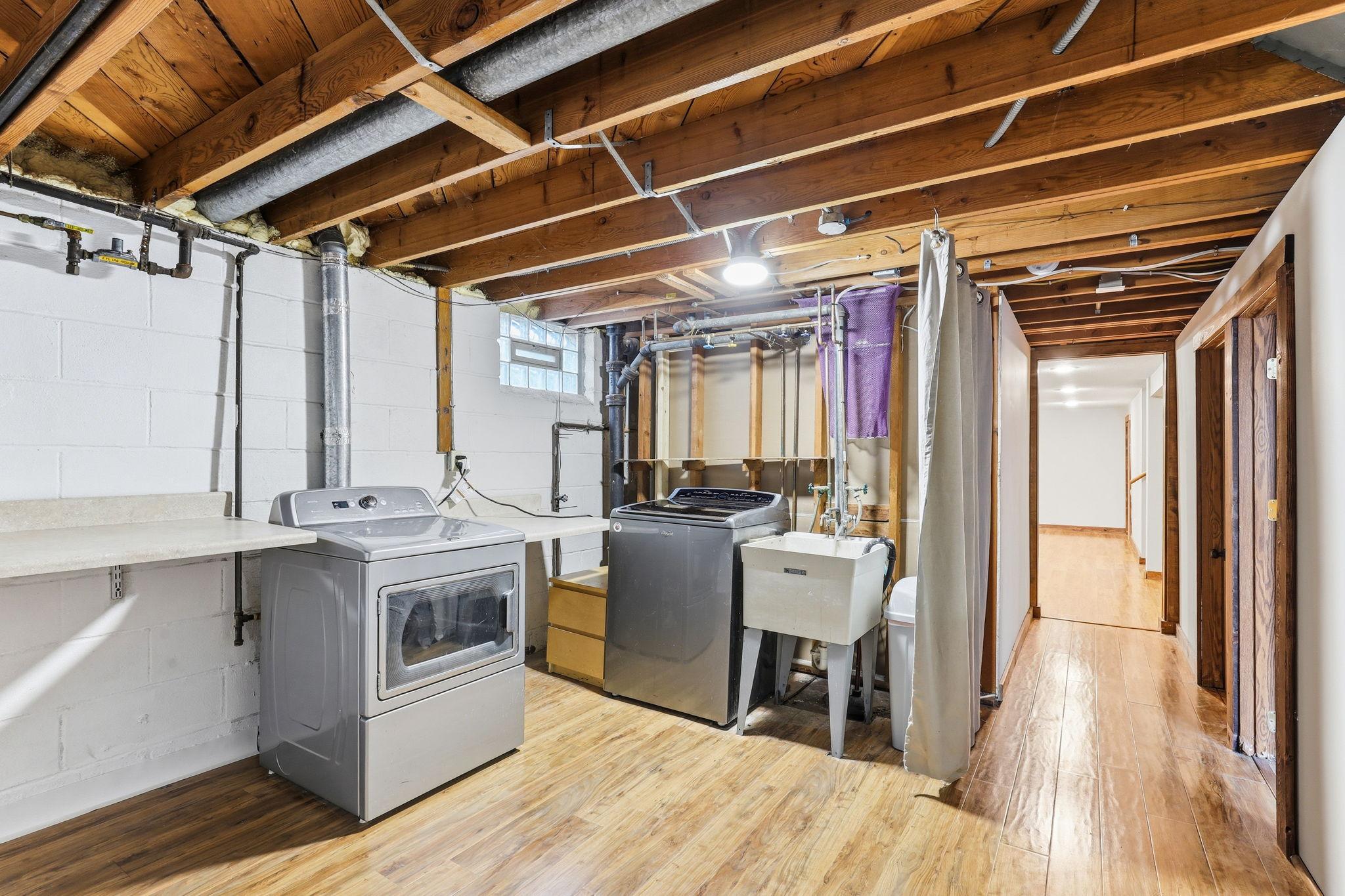 A bright, dedicated laundry space on the lower level with room for folding, sorting, and storage. The fresh, organized layout makes everyday chores feel easier and more comfortable.